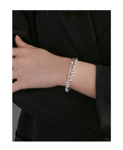 Detailed view of S925 silver beaded bracelet with heart crystal on model's wrist