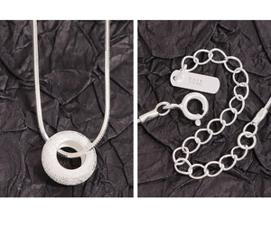 Detailed macro view of S925 sterling silver frosted donut pendant and snake chain buckle