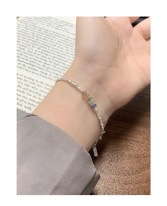 Detail of S925 sterling silver chain bracelet with four colored crystal beads on wrist