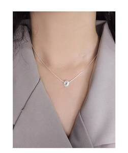 Detail of S925 sterling silver frosted doughnut pendant necklace on model's neckline