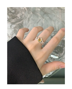 Detail of S925 silver ring featuring crossed lines and an oval moonstone on lace background