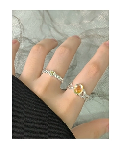 Detail of S925 silver rings set with heart-shaped and oval colorful moonstones on finger