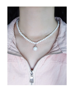 Close-up of minimalist S925 silver necklace with elegant white round pearls on a model