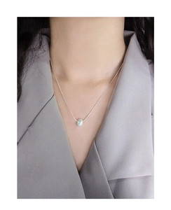 Close-up of S925 sterling silver donut pendant with textured finish on a snake chain