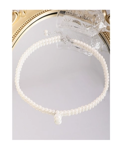 Macro detail of S925 silver pearl necklace with droplet pendant on vintage mirror