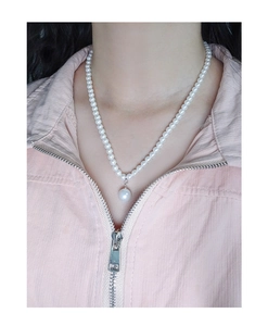 Close-up of a minimalist S925 silver necklace with white pearls and a large pearl pendant