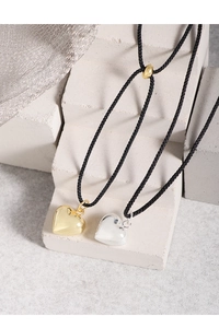 Détail de pendentifs cœur en or et argent sur cordons noirs réglables pour femmes