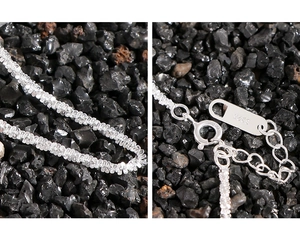 Detail view of S925 sterling silver chain with lobster clasp and hallmark on black rock