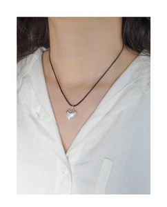 Gros plan d'un pendentif cœur en argent sur un cordon noir ajustable pour femme