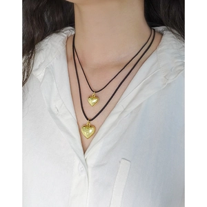 Collier double rang en cordon noir avec pendentifs en forme de cœur doré