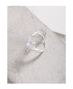 Detail of S925 silver irregular texture ring with glowing moonstone on industrial background