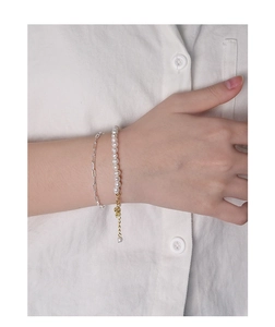Dettaglio del bracciale in argento S925 con catena a graffetta e perle naturali al polso