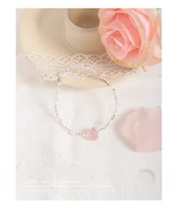 Macro shot of silver beaded bracelet with pink strawberry crystal and pearls on lace