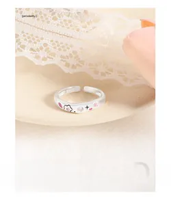 Macro view of S925 silver ring with irregular wavy band and pink zircon floral details