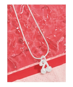 Gros plan du pendentif cerise en argent S925 sur une chaîne serpent fine et élégante