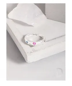 Macro shot of S925 sterling silver ring with colorful heart and star enamel charms