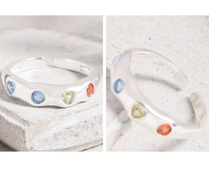 Detail of S925 silver ring with colorful heart-shaped zircons and textured band surface