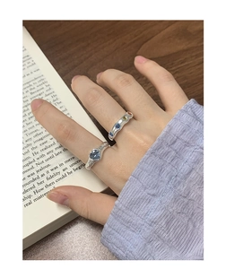 Detail of S925 silver rings with heart-shaped blue gem and colorful zircon inlays