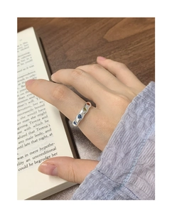 Detail of silver S925 ring with irregular texture and four colorful zircon stones