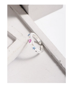 Macro detail of S925 sterling silver ring with colorful heart and star inlay patterns