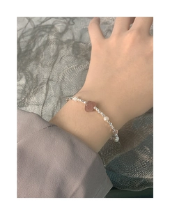 Detail of beaded silver bracelet with strawberry quartz heart and pearls on wrist