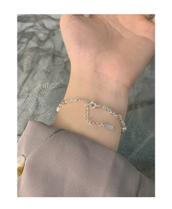Detailed close-up of S925 sterling silver tag and pearls on adjustable women bracelet