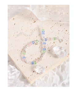 Detail of S925 sterling silver tag and faceted colorful crystal beads on stone surface