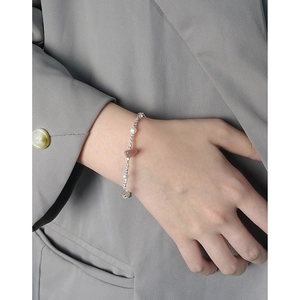 Irregular strawberry quartz and pearl S925 silver bracelet worn on a female wrist