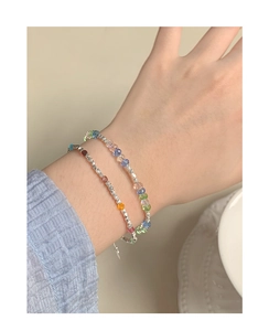 Close-up of stacked colorful crystal bead bracelets and silver irregular beads on wrist