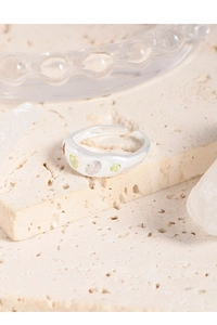 Close-up of S925 silver wave ring with green and clear zircon stones on stone display