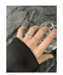 Macro shot of S925 silver rings with colorful zircon stones on textured dark stone