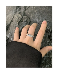 Close-up of S925 sterling silver ring with colorful zircons on a dark rock background