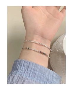 Detail of layered S925 silver bracelet with colorful tourmaline beads on a woman's wrist