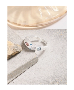 Macro view of S925 sterling silver ring with colorful inlaid zircons on stone surface
