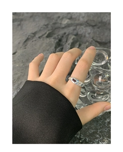 Close-up of S925 silver irregular ring with zircon stones on model holding glass