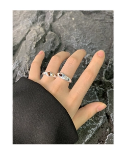 Close-up of S925 silver rings set with colorful zircons on fingers with rock background