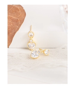 Détail macro de boucles d'oreilles pendantes en zircon coeur doré sur support blanc