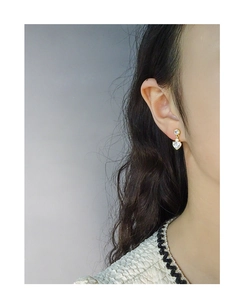 Gros plan détaillé de boucles d'oreilles en argent S925 avec zircon de cœur sur modèle