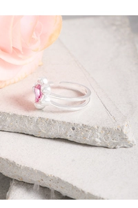 Macro detail of silver S925 ring with pink star-shaped zircon on a stone background