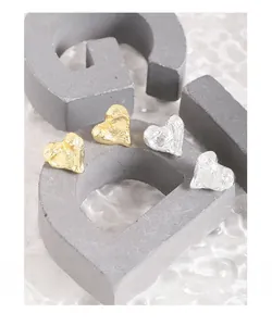 Detail of S925 sterling silver heart earrings with melting texture in gold and silver