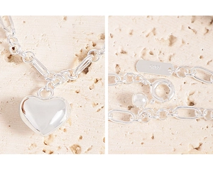 Detailed macro view of S925 sterling silver heart pendant with paperclip chain link
