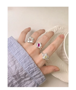 Detailed view of S925 silver rings with colorful zircon flowers and stones on hands