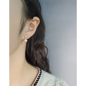 Élégantes boucles d'oreilles cœur en argent S925 et zircon doré portées sur l'oreille