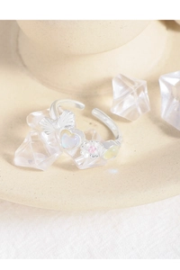 Macro detail of S925 silver ring featuring a bow, opal heart, and floral accents