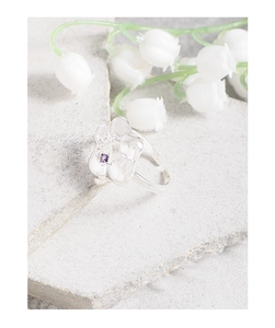 Detail of S925 silver flower ring with square purple zircon on stone surface