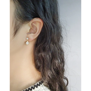 Élégantes boucles d'oreilles cœur en zircon doré portées par un mannequin pour un look chic