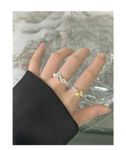 Detail of S925 silver ring set with bow design and opal heart gemstone on finger