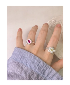 Detail of S925 silver flower rings with magenta gemstone and daisy design on finger