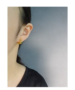 Close-up of elegant double hoop gold earrings worn by a model with polished finish