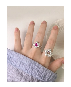 Detailed view of S925 silver rings with red and purple zircon flowers on a hand